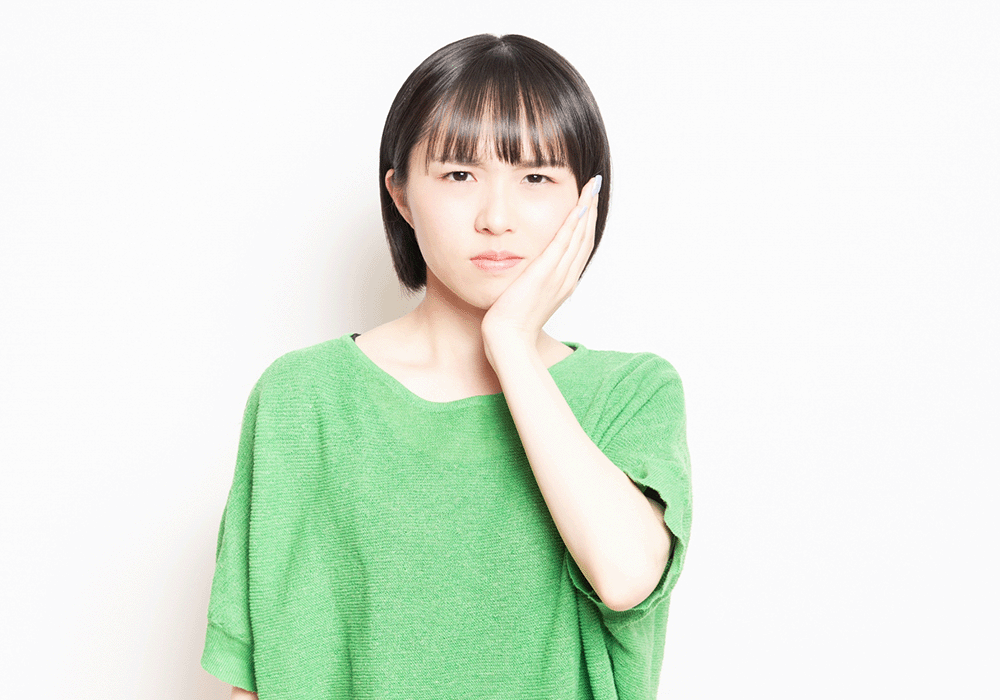 頬を抑える女性